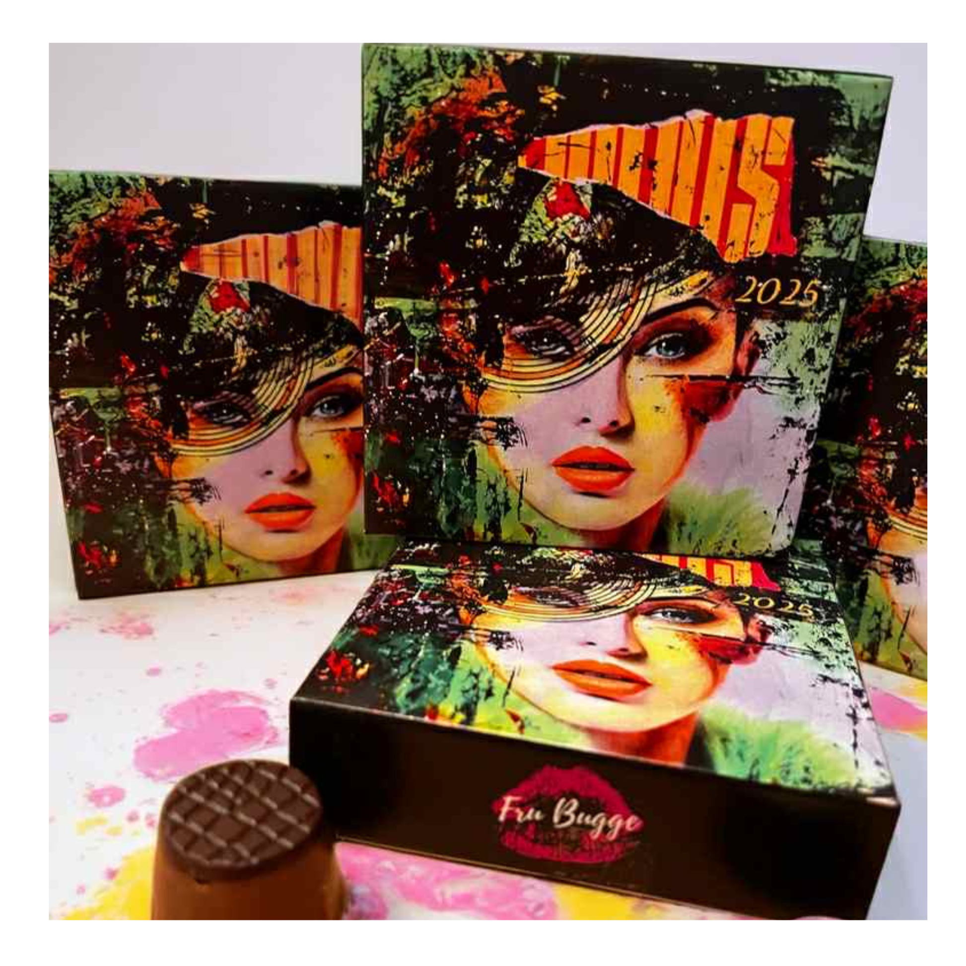 “Esken fra Fru Bugges kunstsjokolade 2025 edition, sjokoladebiter lagt ved siden av og årets fargerike kunstmotiv i bakgrunnen.”